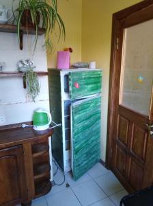 a room with a green refrigerator next to a desk at Apartment on Voli Avenue 21 in Lutsk