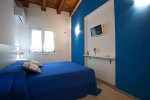 una camera da letto blu con un letto e una finestra di Il Rifugio Del Tempo a Roccasecca