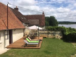 een terras met 2 ligstoelen en een tafel bij Gîte des Cochards in Seigy