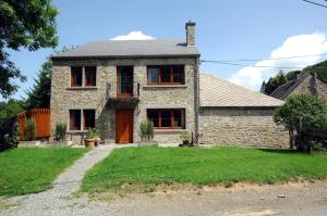 a stone house with a red door and a yard at Sy Select place in Ferrières