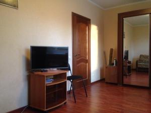 sala de estar con TV de pantalla plana en un soporte de madera en City Inn Apartment Sokolniki, en Moscú