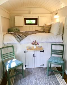 ein Bett und zwei Stühle in einem winzigen Haus in der Unterkunft Riverside House in Newport