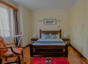 a bedroom with a bed and a chair at The Cottage Guest House Gigiri in Nairobi