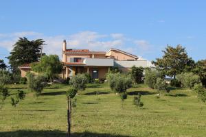 a house in the middle of a field with trees at Guest house Villa di Judighes in Cerveteri