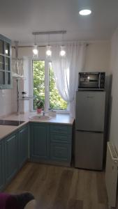 カリーニングラードにあるApartments Sweet Homeのキッチン(青いキャビネット、シンク、電子レンジ付)