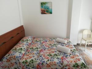 a bed with a floral bedspread and two pillows on it at Venice Vacation House in Marghera