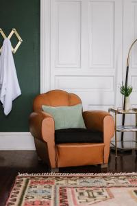 a brown chair in a room with a green wall at Carr Mansion in Galveston
