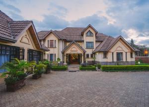 a large house with a brick driveway at The Cottage Guest House Gigiri in Nairobi