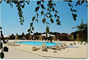 a swimming pool with lounge chairs and a resort at Mobile Homes Peroš in Zaton