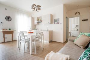 een keuken en een woonkamer met een witte tafel en stoelen bij Apulianstay-La Dimora di Sofia in Monopoli