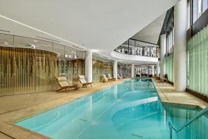 una gran piscina en un edificio con sillas en Stylish Waterfront Apartment With Docklands Views, en Melbourne