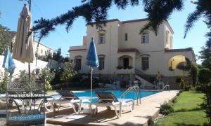 une maison avec une piscine, 2 chaises et un parasol dans l'établissement Villa Pomme d'Or, à Midelt