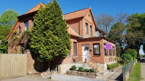 ein Backsteinhaus mit einem Baum davor in der Unterkunft Schnucken-Hus in Amelinghausen