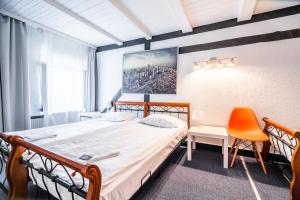 a bedroom with a large bed and a chair at Great Polonia Jelenia Góra City Center in Jelenia Góra +142 photos