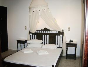 a bedroom with a bed with white sheets and pillows at Evgatis Hotel in Kondiás