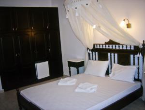 a bedroom with a bed with white towels on it at Evgatis Hotel in Kondiás