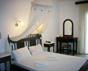 a bedroom with a bed with a dresser and a mirror at Evgatis Hotel in Kondiás