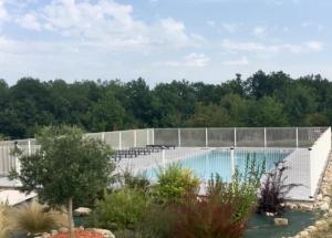 a swimming pool with a fence and trees at Gîtes Dans une Maison d'hôtes "Lieu Dit Cruzel" in Moissac