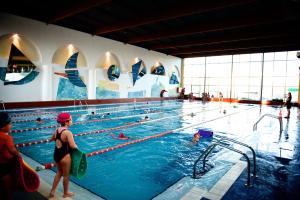 un grupo de personas nadando en una piscina en Hotel Torresport, en Torrelavega
