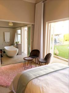 1 dormitorio con baño con bañera y bañera en Maison Jacaranda, en Johannesburgo