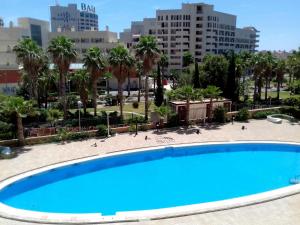 una gran piscina azul con palmeras y edificios en ACV - Aguamarina-2ª línea, planta 7, norte en Oropesa del Mar