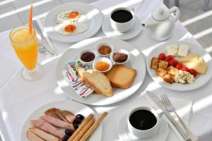 a white table topped with plates of breakfast foods at Ambelas Mare Apartments in Ambelas