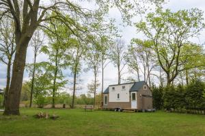 a tiny house in the middle of a field at Tiny House in Ootmarsum