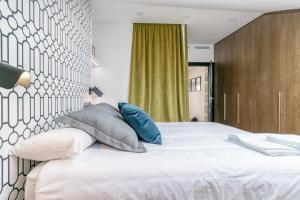 Łóżko lub łóżka w pokoju w obiekcie Livemalaga Centro Suites
