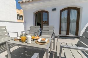 stół i krzesła na patio z sokiem pomarańczowym w obiekcie Livemalaga Centro Suites w Maladze