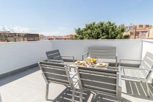 taras ze stołem i krzesłami na balkonie w obiekcie Livemalaga Centro Suites w Maladze