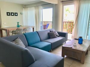 a living room with a blue couch and a table at Palapa Beach Resort Curacao in Jan Thiel