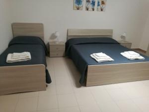 sypialnia z 2 łóżkami i ręcznikami w obiekcie B&B Nonna Lina w mieście Marsala