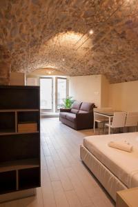 a room with a bed and a couch and a table at La Bellavita del Garda Luxury Apartments in San Felice del Benaco