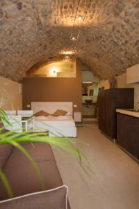 a room with a bed and a table and a kitchen at La Bellavita del Garda Luxury Apartments in San Felice del Benaco