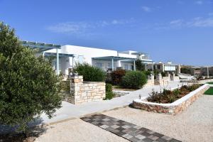 a house with a landscaping in front of it at Ambelas Mare Apartments in Ambelas