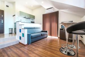 a living room with a blue couch and a bar stool at White Apartman Siófok in Siófok