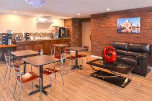 a restaurant with tables and chairs and a leather couch at Motel 6 Putnam CT in Putnam