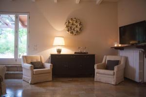 a living room with two chairs and a tv at Casa vacanze a Rubbianello in Monterubbiano