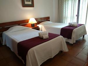 a hotel room with two beds and a lamp at Apartamentos da Balaia in Albufeira