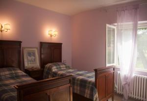 a bedroom with two beds and a window at Casa vacanze a Rubbianello in Monterubbiano