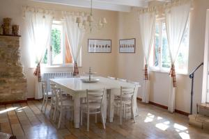 a dining room with a white table and chairs at Azienda ASIS in Monterubbiano