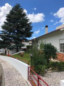 una casa con un árbol y una valla en Quinta Nova do Almeida en Alcobaça