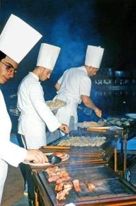 un grupo de chefs que preparan comida a la parrilla en Hotel Caravelle, en Cattolica