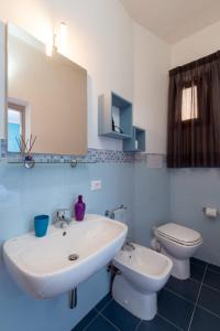 ein Badezimmer mit einem weißen Waschbecken und einem WC in der Unterkunft Il Torrazzo da Francesca in San Vito lo Capo