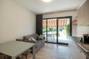 eine Küche und ein Wohnzimmer mit einem Sofa und einem Tisch in der Unterkunft Giardino sul Garda in Sirmione
