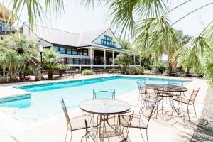 una piscina con mesas y sillas frente a una casa en Hillside Boutique Hotel, en Castroville