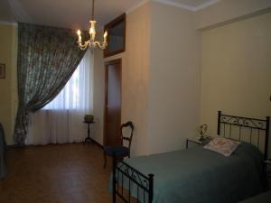 a bedroom with a bed and a window with a chandelier at Vacanze Senesi in Siena