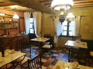 un restaurante con mesas y sillas y una lámpara de araña en Carpe Diem, en Navaridas