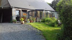 a greenhouse with potted plants in front of it at La martre in Saint-Sylvestre-de-Cormeilles +10 photos