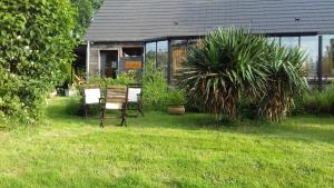 two chairs sitting in the grass in front of a house at La martre in Saint-Sylvestre-de-Cormeilles